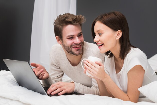 Happy couple looking at laptop