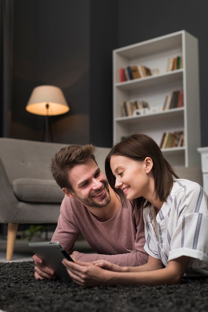 Free photo happy couple looking at tablet