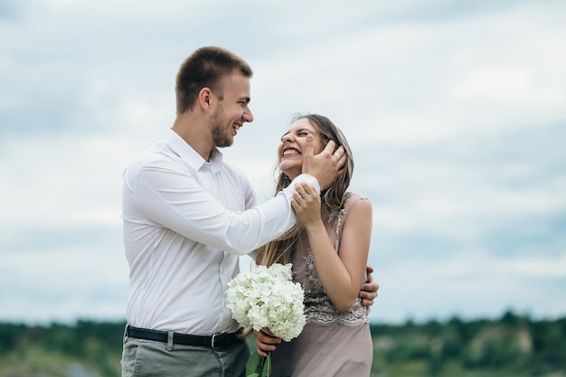 The happy couple in love embracing near river