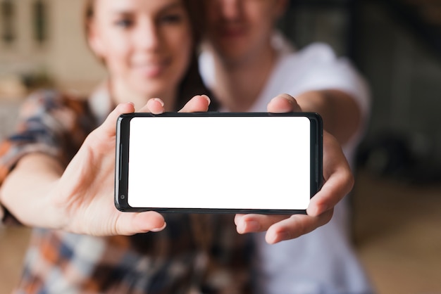 Happy couple in love showing smartphone screen