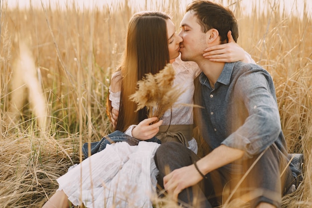 Happy couple in love in wheat field at sunset