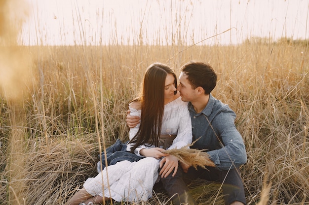 Happy couple in love in wheat field at sunset