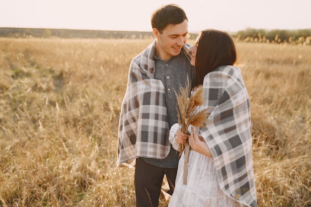 Счастливая пара в любви в пшеничном поле на закате
