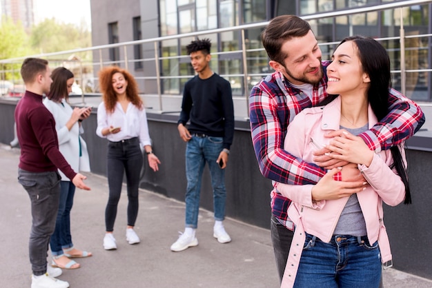 Happy couple loving each other outdoors near building