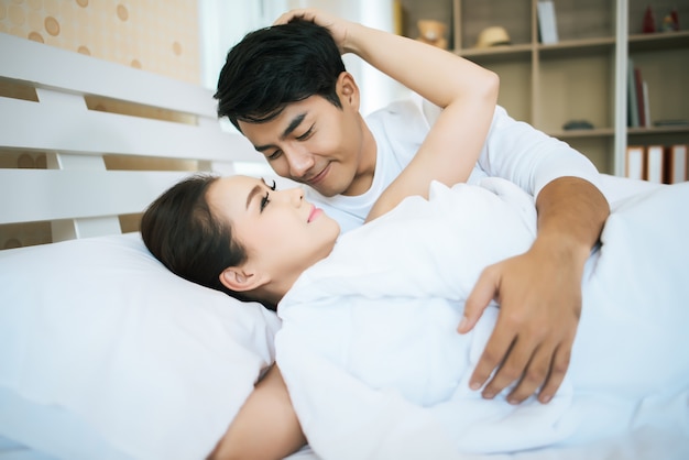 Happy couple lying together in bed