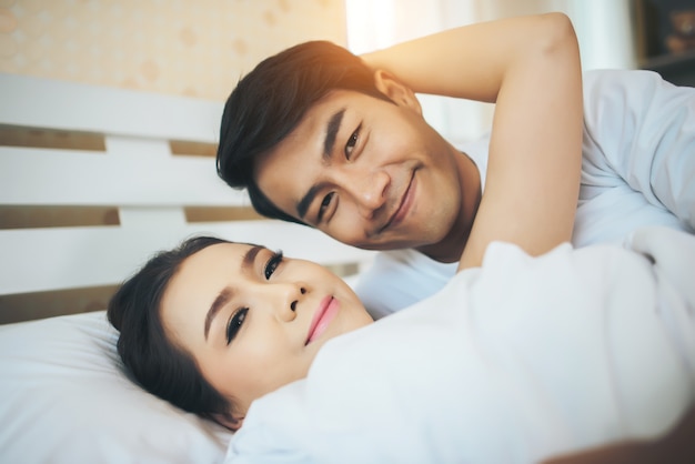Happy couple lying together in bed