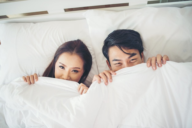 Happy couple lying together in bed