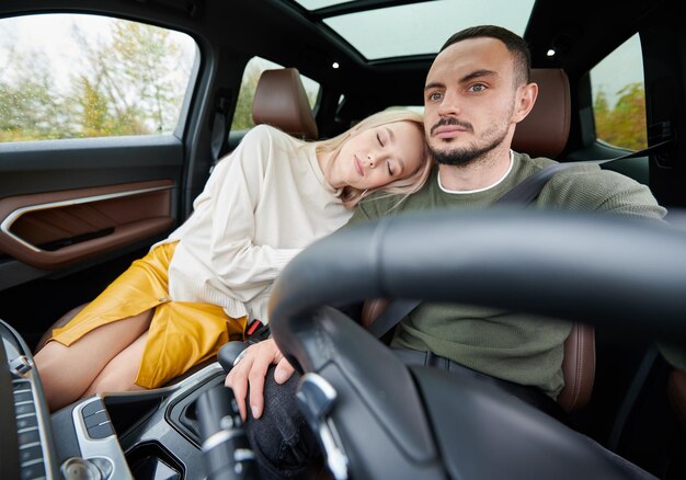 Happy couple man and woman traveling in car