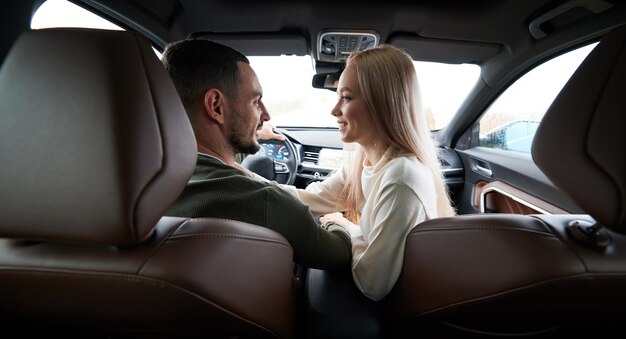 Happy couple man and woman traveling in car