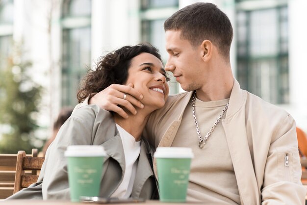 Foto gratuita una coppia felice all'aperto vicino a un caffè