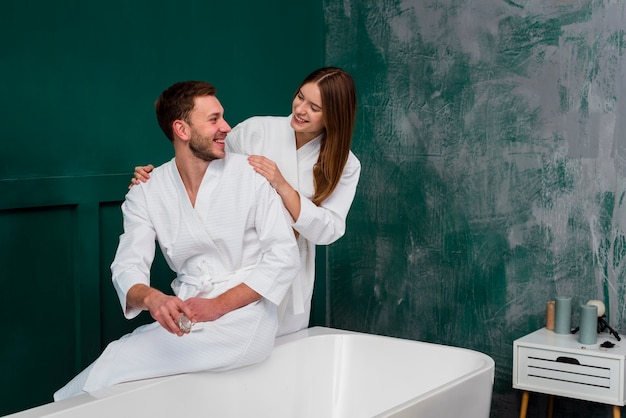 Happy couple posing in bathrobes with copy space