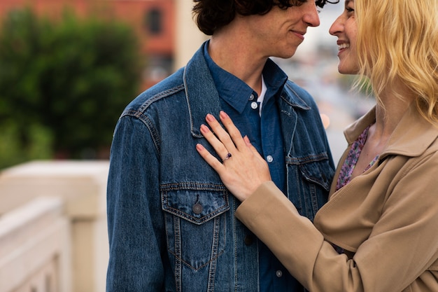 Счастливая пара позирует на улице в городе с обручальным кольцом