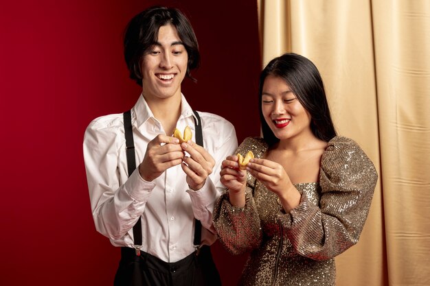 Happy couple reading message from fortune cookie for chinese new year