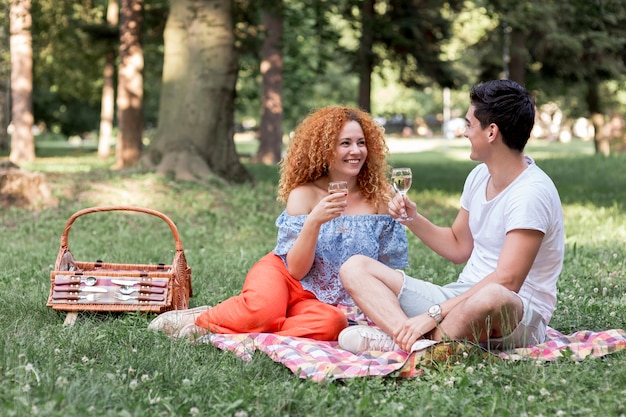 Foto gratuita coppie felici che si rilassano su una coperta al parco