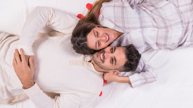 Happy couple resting on bed 