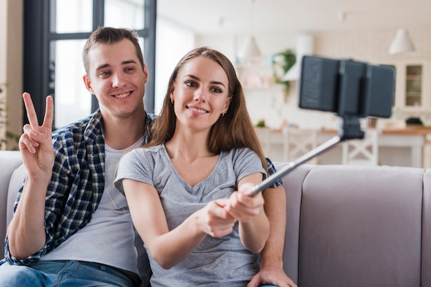 Happy couple shooting selfie in apartment