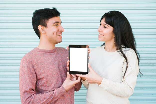 Happy couple showing digital tablet