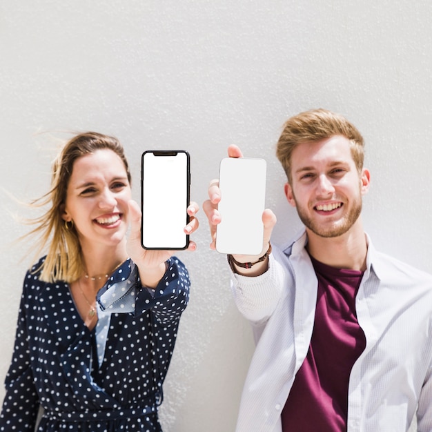 Foto gratuita coppia felice che mostra smartphone