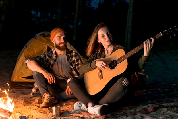 Happy couple singing and playing the guitar