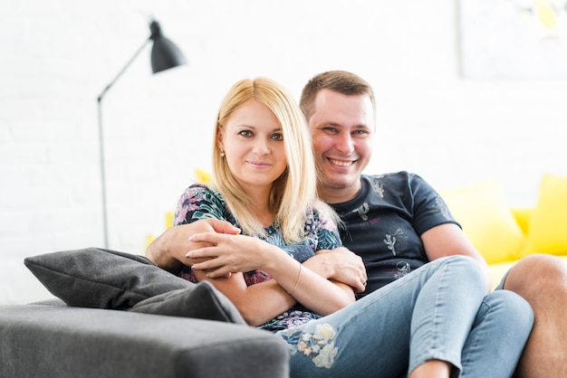 Free photo happy couple sitting on sofa