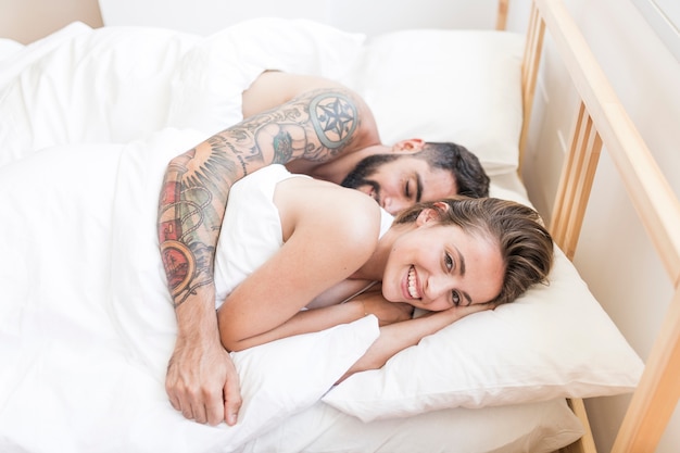 Happy couple sleeping together on bed