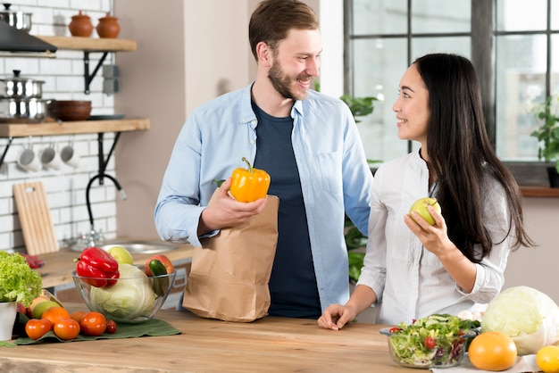 Happy couple standing in kitchen looking at each other in kitchen