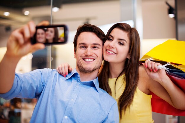 Happy couple taking a photo in the shopping mall