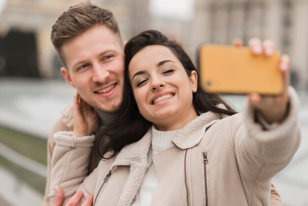 밖에 서 selfie를 복용하는 행복 한 커플