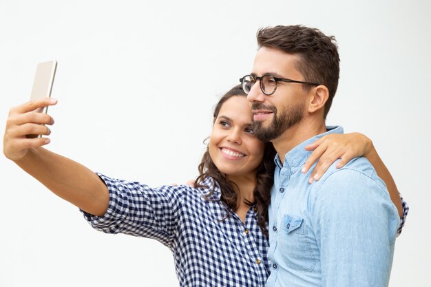 Happy couple taking selfie with smartphone