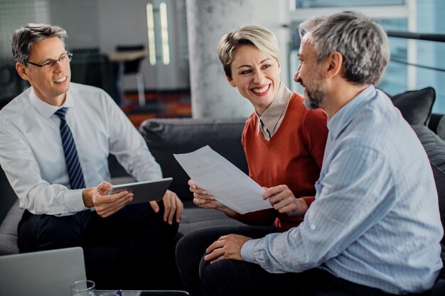 Happy couple talking while having consultations with their agent in the office