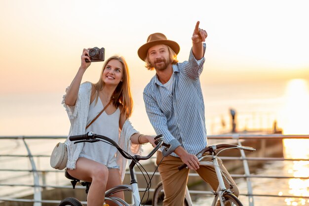 happy couple traveling in summer on bicycles, taking photos