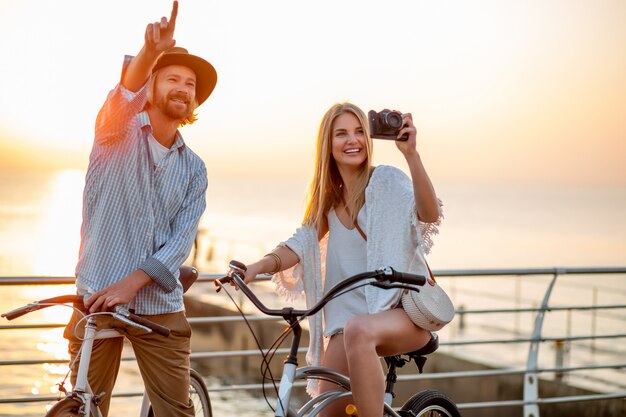 happy couple traveling in summer on bicycles, taking photos