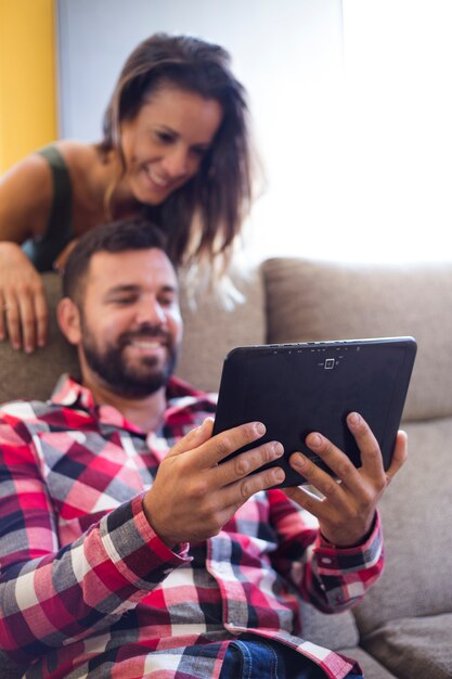 Happy couple using digital tablet at home