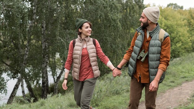 Free photo happy couple walking on a trail in nature