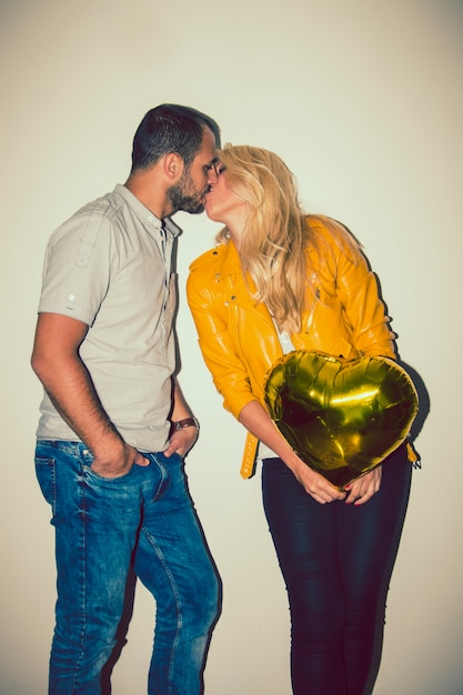 Happy couple with balloon kissing