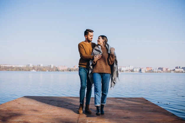 Happy couple with blanket by the river