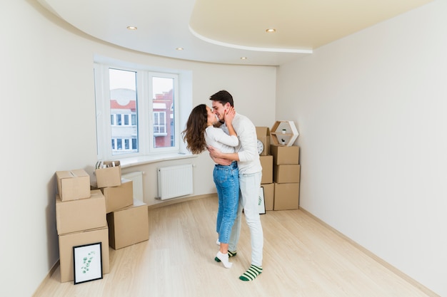 Happy couple with cardboard boxes in new house