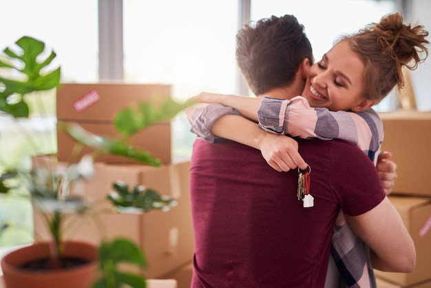 Happy couple with keys of new apartment