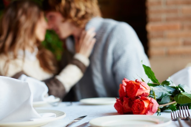 Happy couple with roses bouquet on a date