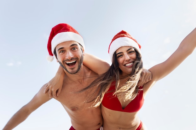 Happy couple with santa hats low angle