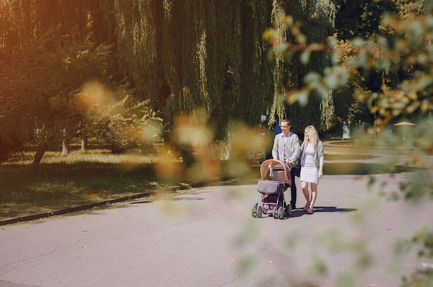 Happy couple with stroller in the park