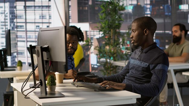 Happy coworker in wheelchair bumping fists with programmer