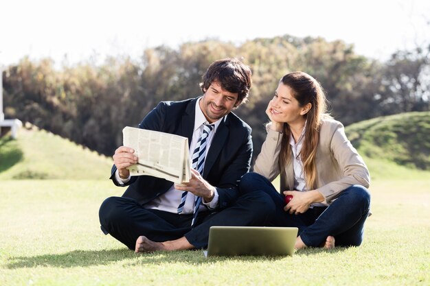 Happy coworkers reading news outdoor