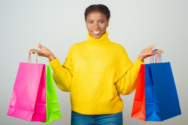 Happy customer holding and showing colorful shopping bags