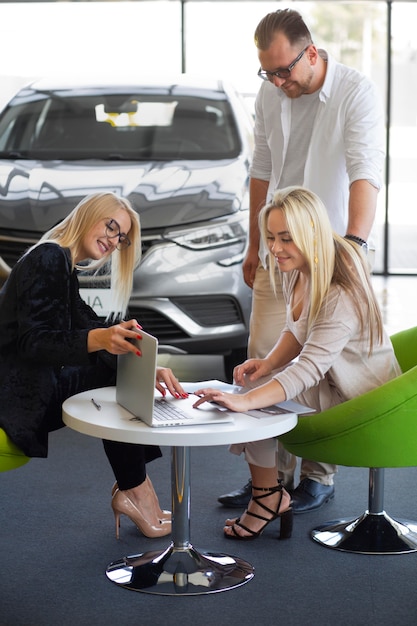 Happy customers in car dealership