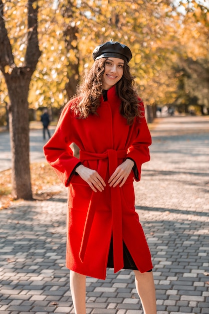따뜻한 빨간 코트 가을 유행 패션, 거리 스타일을 입고 공원에서 산책하는 곱슬 머리를 가진 행복 귀여운 매력적인 세련된 웃는 여자, 베레모 모자를 쓰고