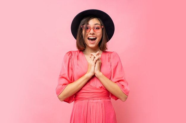 Happy cute girl in pink dress posing