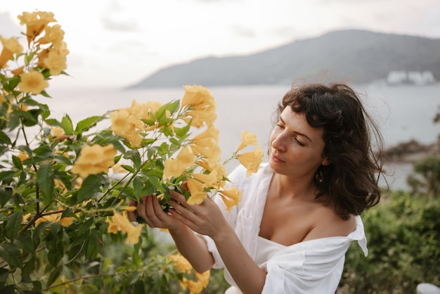 Happy cute woman look at flowers