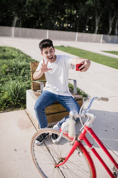 Happy cyclist making hand gesture while taking selfie