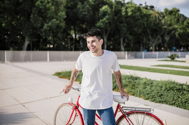 Happy cyclist posing in front of his bicycle